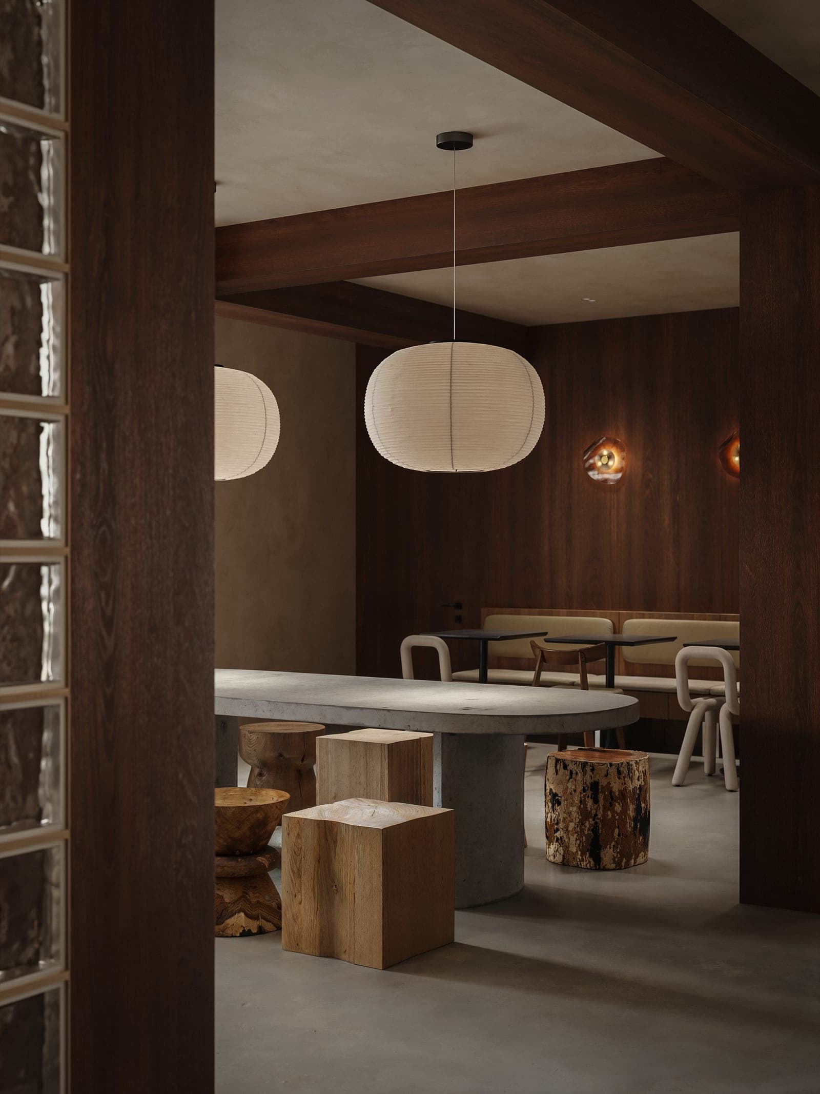 A paper lantern over a concrete table with timber stools